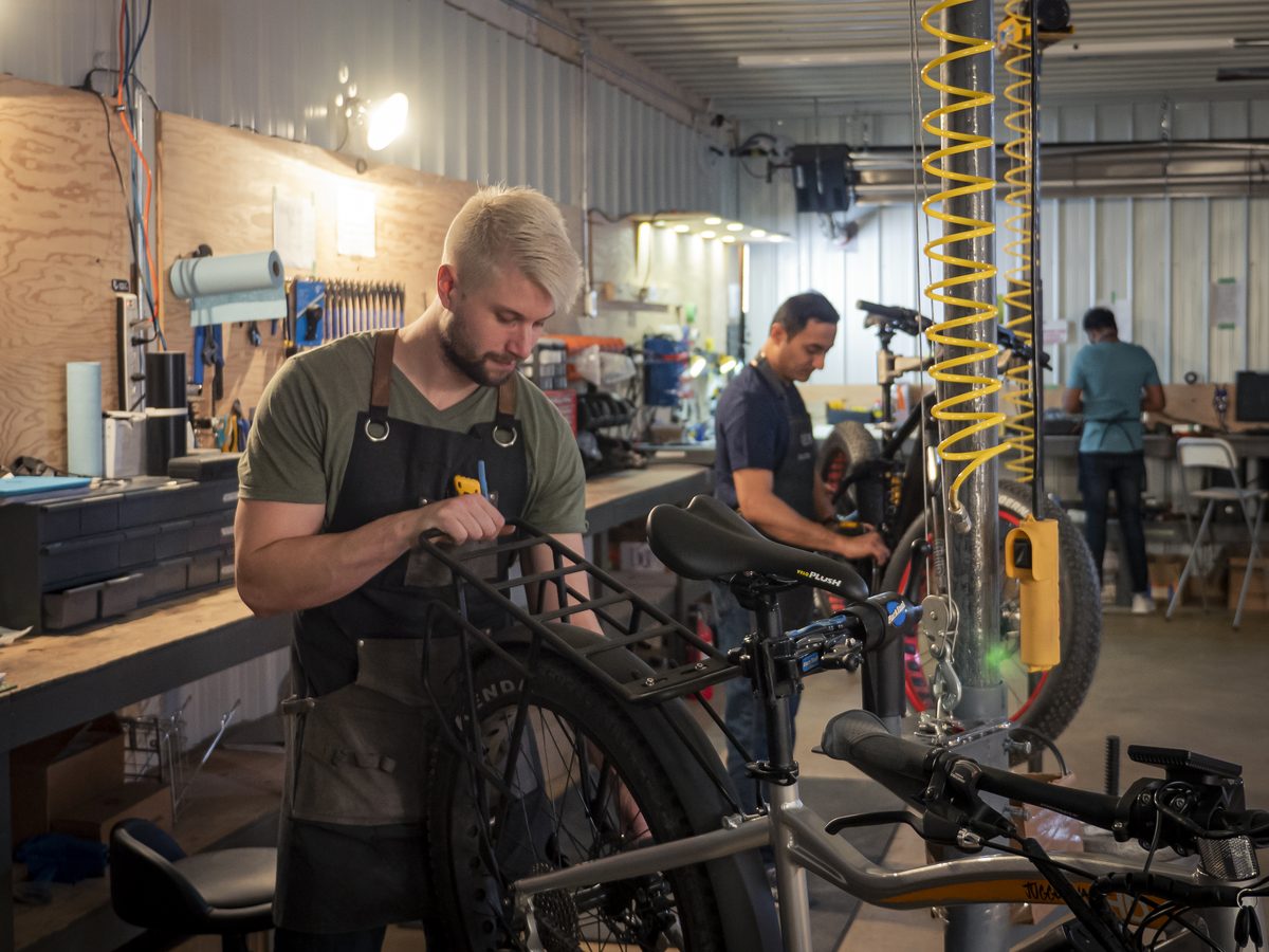 A Biktrix technician assembling a fat-tire eBike on a stand in the Saskatoon warehouse
